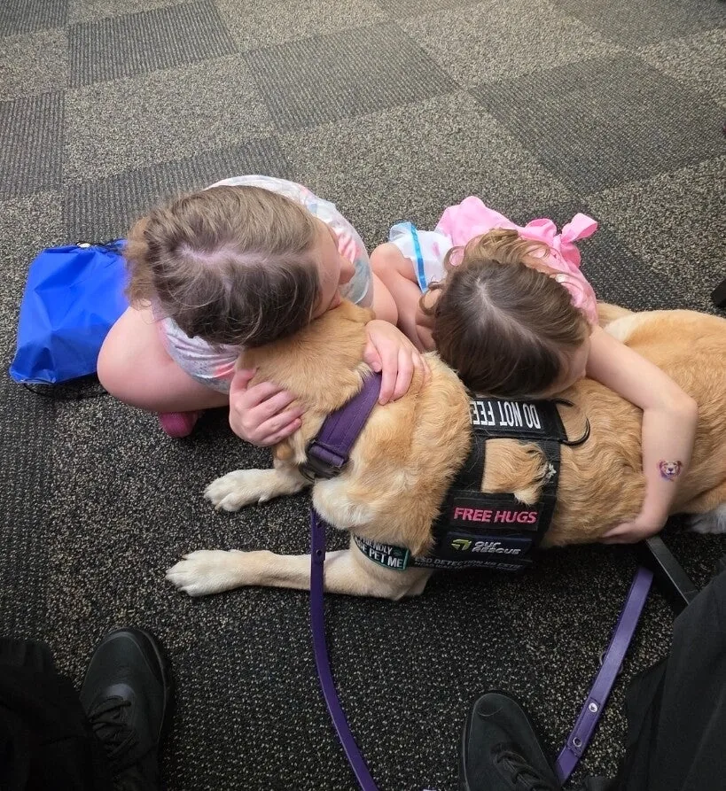 Children hugging Estie during a library visit